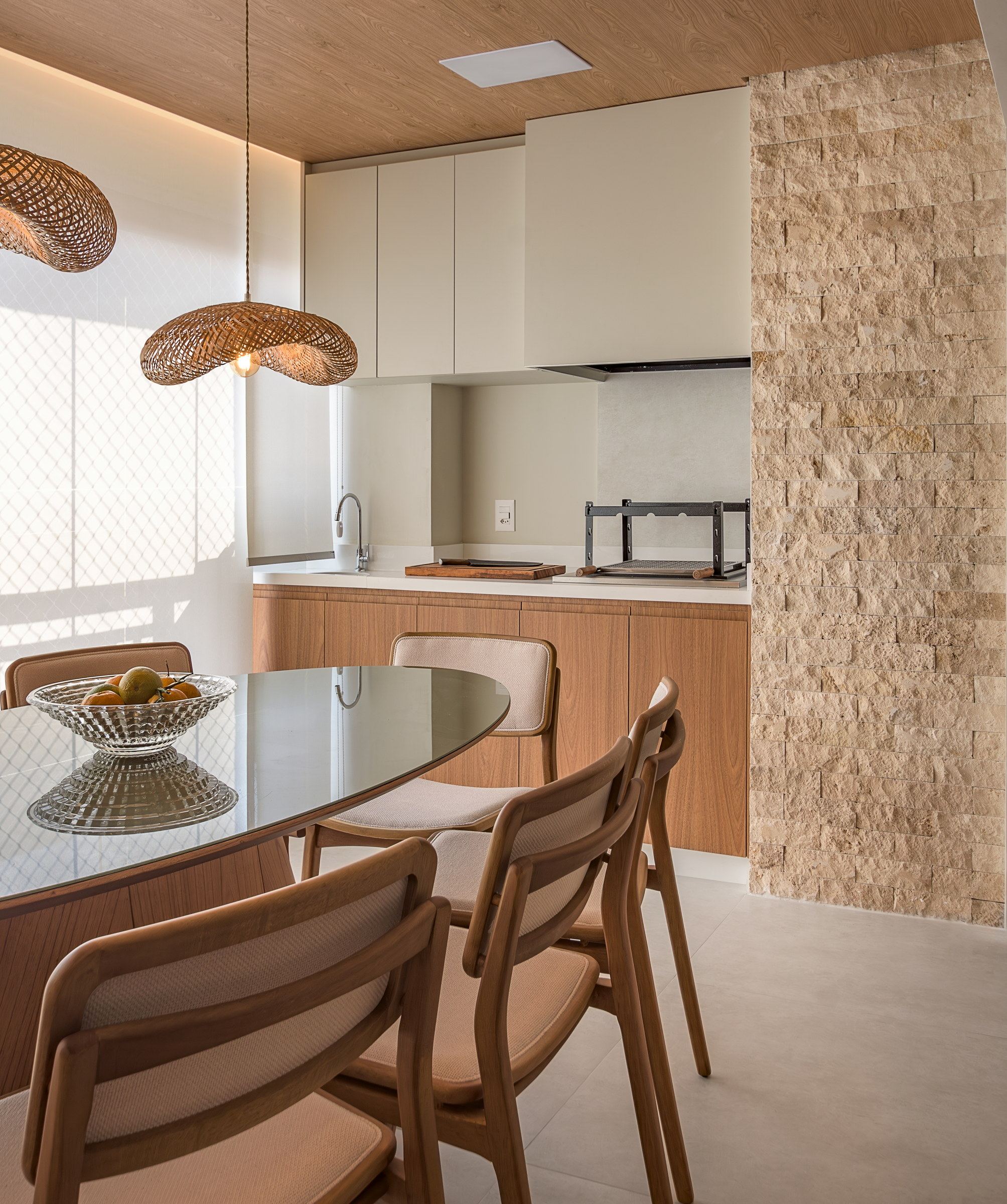 Sala de jantar com parede revestida e iluminação pendente