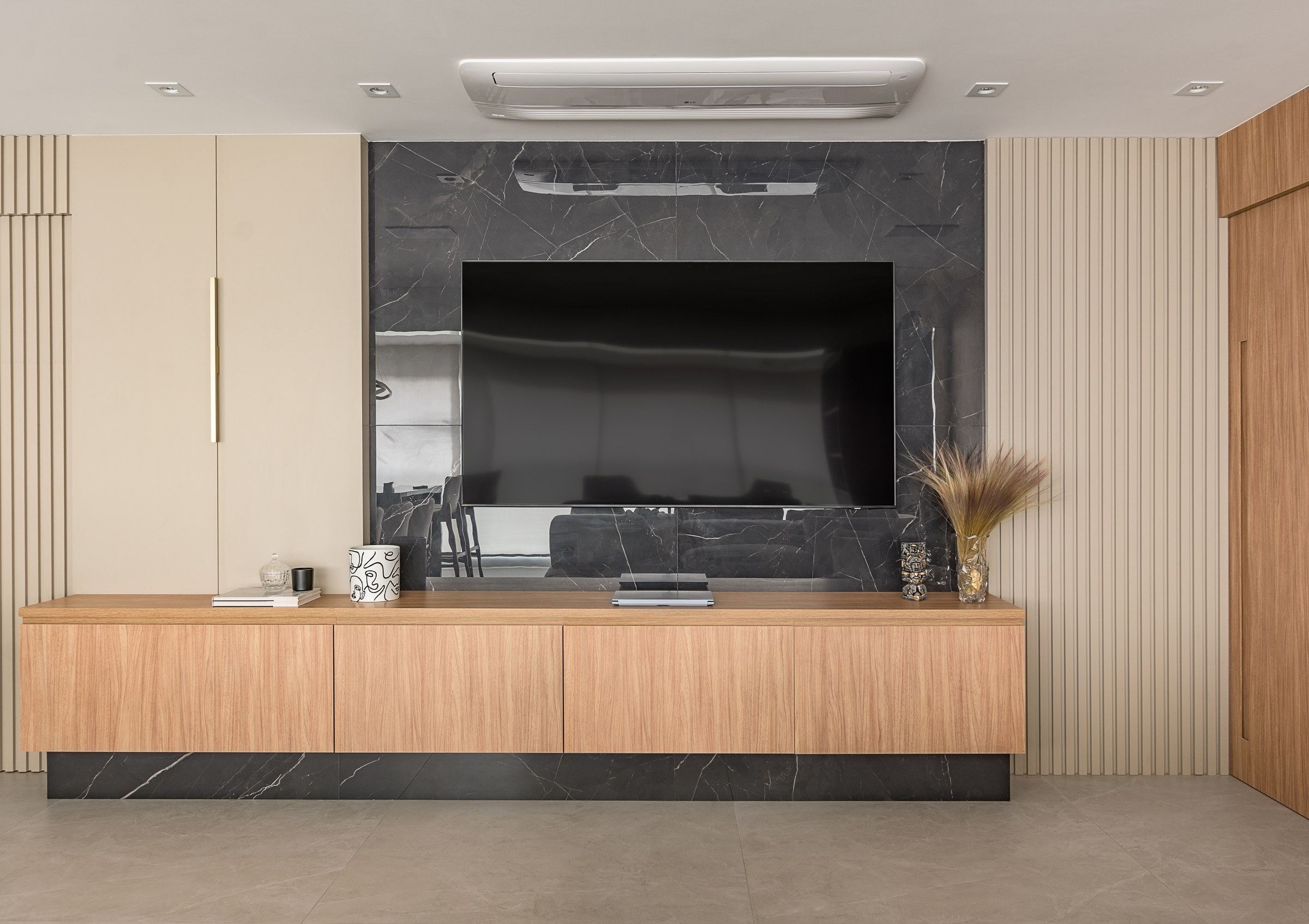 Parede da sala revestida do piso ao teto, com ponto de TV embutido