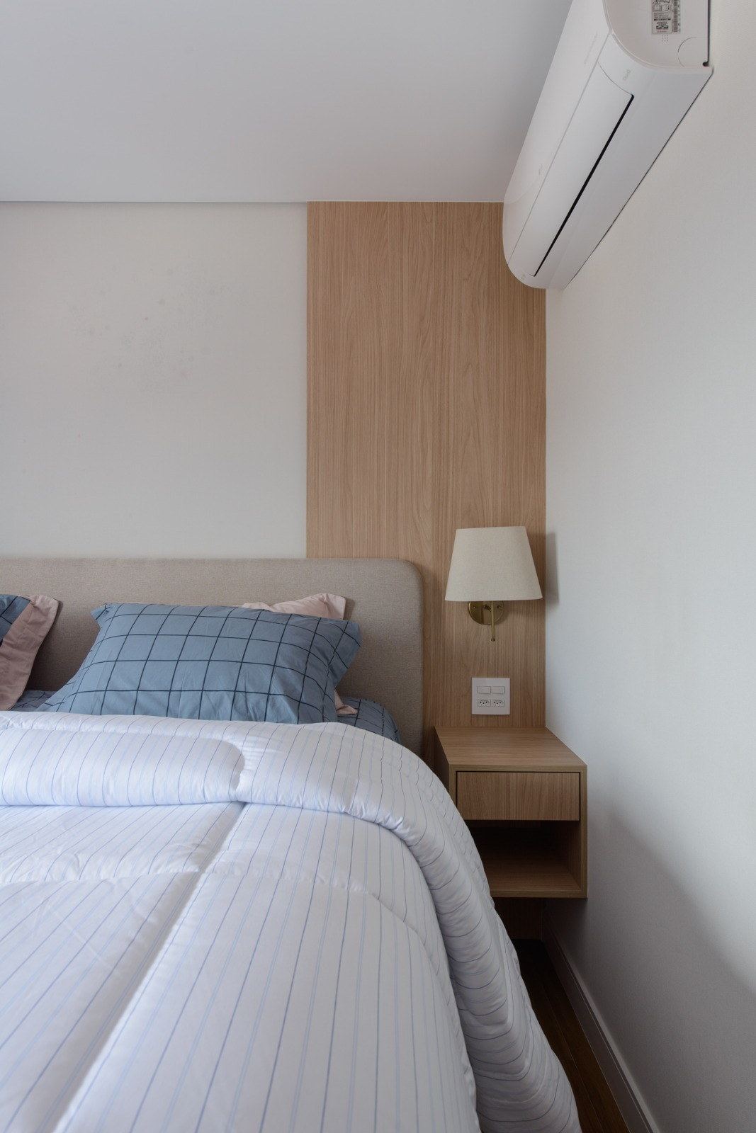Quarto com ar-condicionado instalado acima da cabeceira